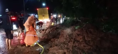 Longsor di Limbangan Tutup Jalan Nasional, Evakuasi Material Masih Berlangsung Petugas menangani material longsor di Garut yang menghalangi jalan raya