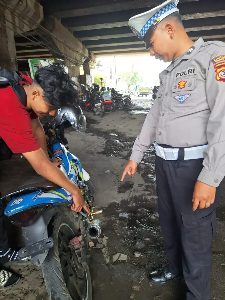 Petugas menindak pengendara motor yang menggunakan knalpot brong di Dayeuhkolot.