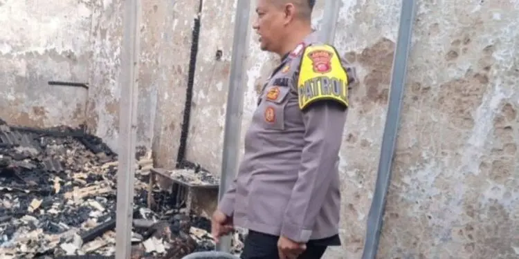 Polisi meninjau lokasi kebakaran di sebuah kios pecel lele yang menewaskan dua orang di wilayah Gunung Putri, Bogor. 