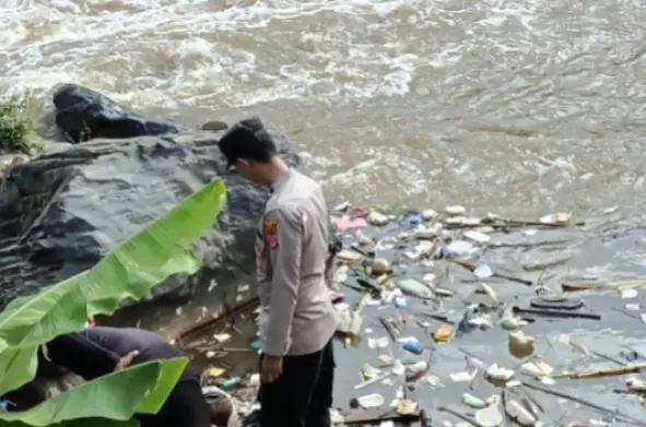 Petugas kepolisian mengevakuasi jasad bayi berjenis kelamin laki-laki di pinggir aliran Sungai Cimanuk, Kamis (23/10/2025). (ridaningsih/koranmandala)