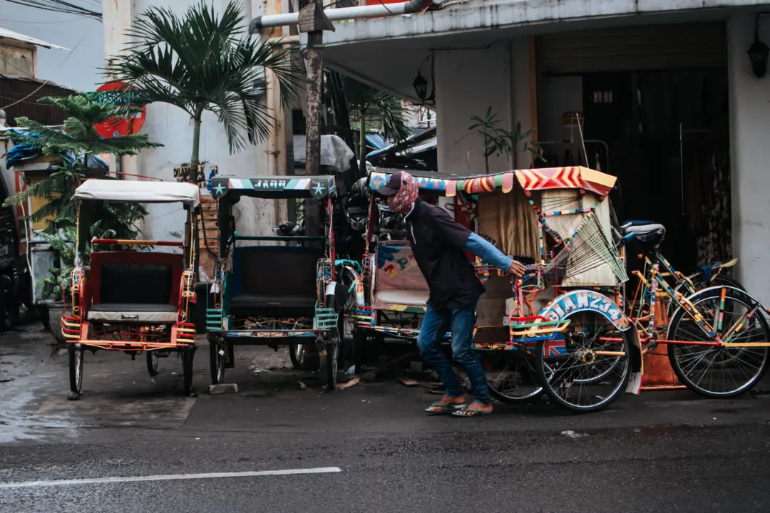 Becak melintas di antara sepeda motor dan kendaraan umum di jalan Otto Iskandar Dinata, Kec. Andir, Kota Bandung, Jawa Barat, pada Rabu (21/1/2026). Muhammad Farhan Rizqi/MG.