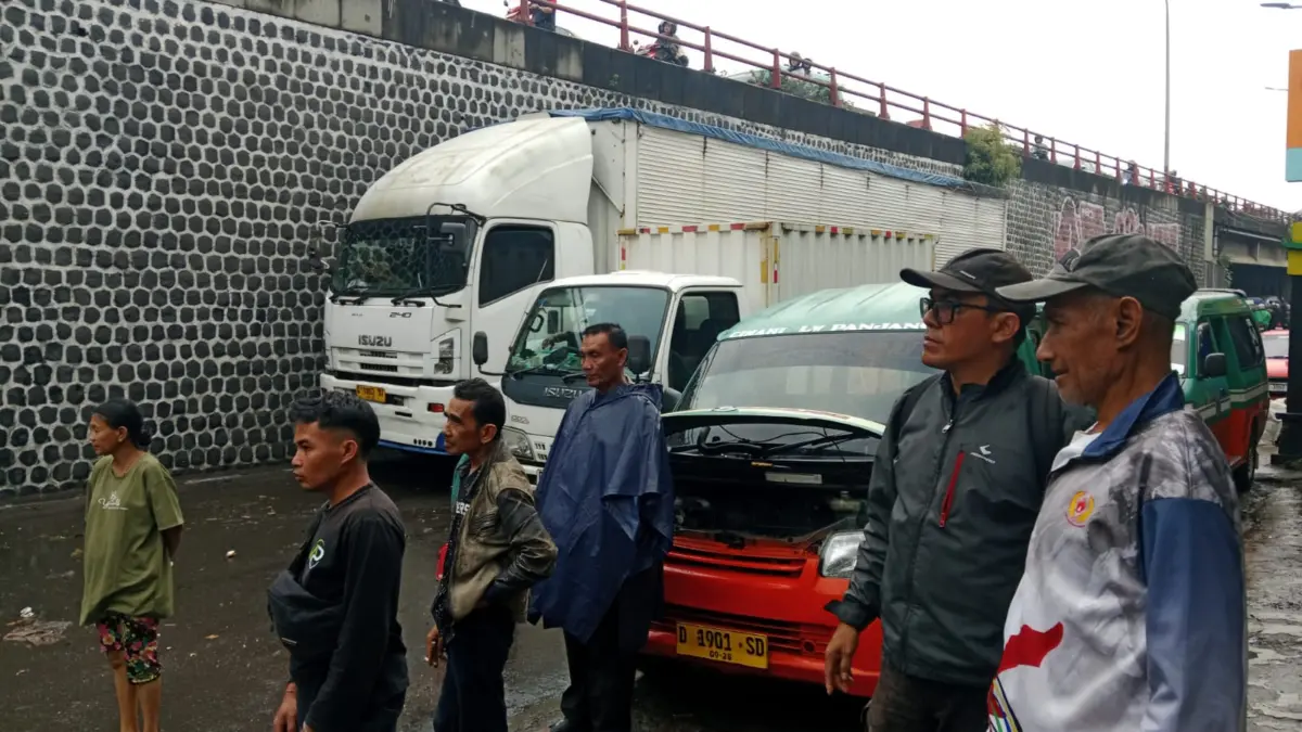 ejumlah kendaraan tertahan di Jalan Raya Cimindi, pengendara memilih menunggu karena tak bisa menerobos genangan banjir