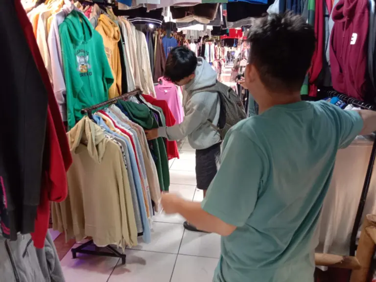 Suara Hati Pedagang Pasar Cimol Gedebage: Bertahan di Tengah Sepinya Thrifting Imbas Larangan Impor Andika (29) pedagang di Pasar Cimol Gedebage, Kota Bandung, sedang melayani pengunjung di kiosnya (27/4/2026)