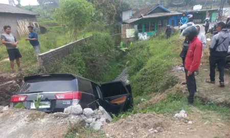 Pengendara Motor Diduga Lepas Kendali, Mobil Innova Terperosok ke Parit di Cisurupan