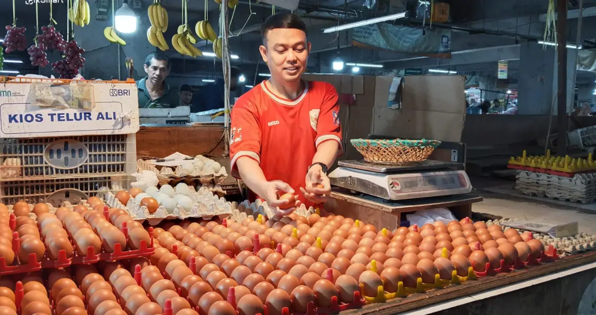 Pedagang Kios Ali menata telur ayam yang dijual di pasar kosambi