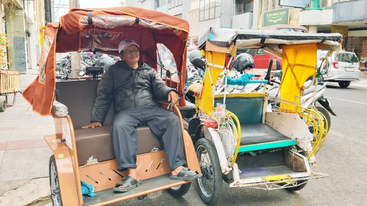 Penarik becak listrik Pepen Abidin (61) saat mangkal di kawasan Pasar Baru Kota Bandung, Selasa 22/9/2026 (Sarah/Koran Mandala)