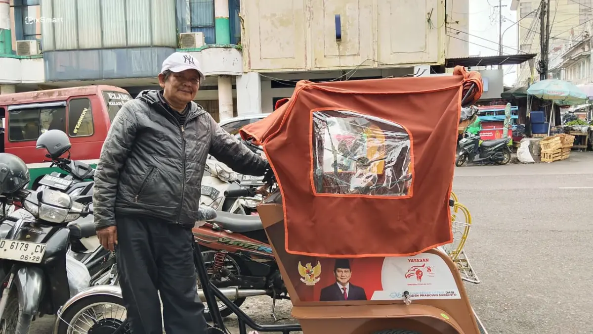 Penarik becak listrik Pepen Abidin (61) saat mangkal di kawasan Pasar Baru Kota Bandung, Selasa 22/9/2026 (Sarah/Koran Mandala)