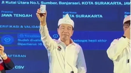 Mantan Presiden Joko Widodo menunjukkan KTA PSI saat safari politik bersama PSI di Kota Bandung. (Istimewa)