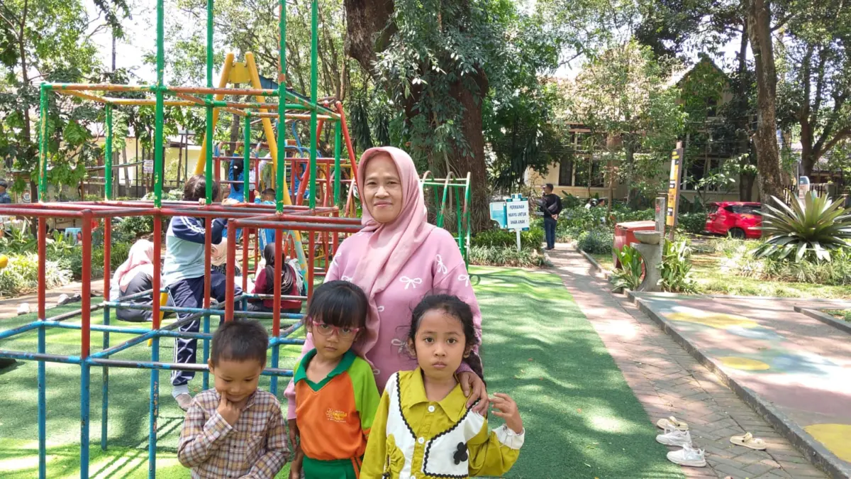 Ibu Atin sedang mengantar cucunya bermain di Taman Cempaka, Kota Bandung (Sarah/Koran Mandala)